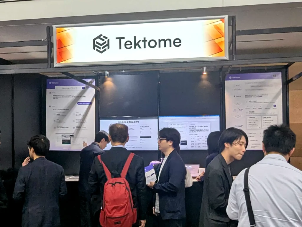 The Tektome stand at Archi Future 2026, with an illuminated sign, demo screens and visitors talking with the team