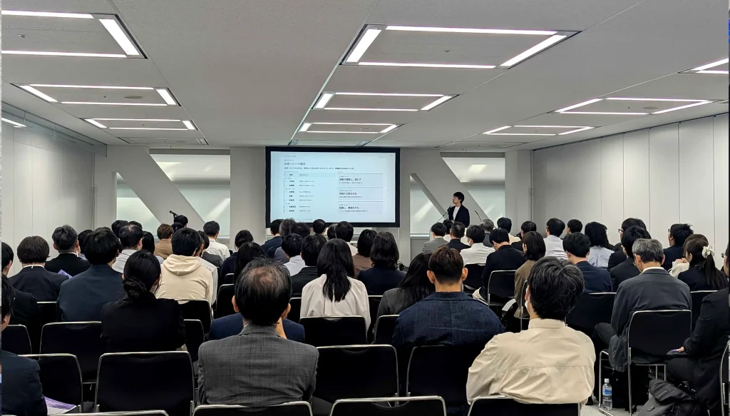 Naoki Kitamura presenting beside a large screen to a full room in the Archi Future 2026 Technical Forum